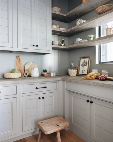 light blue kitchen with cement shelving and countertops