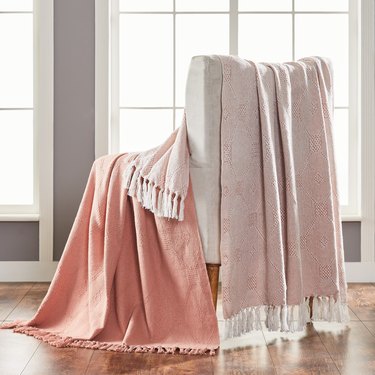 light pink throw blankets hanging over a chair