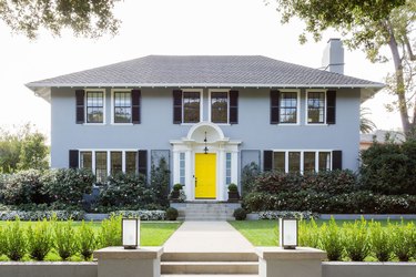 blue-gray traditional home with canary yellow door