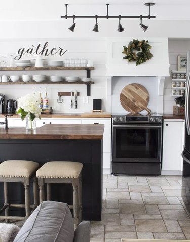 White kitchen corner with black oven, hardware, and refrigerator