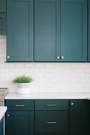 emerald green kitchen cabinets with white subway tile backsplash