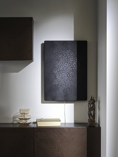 brown furniture piece with black speaker mounted on the wall