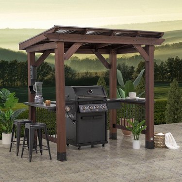 A wooden gazebo over a grill