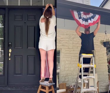 Two people hanging up American flags on a porch