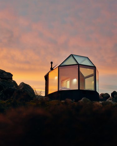 glass house in desert at sunset