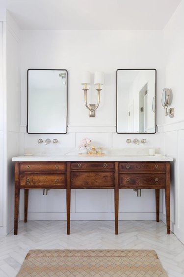 A double bathroom vanity with two mirrors and wall scone.