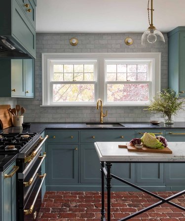 Turquoise kitchen cabinetry with black counterops