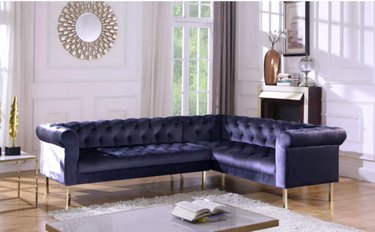 blue sectional sofa near coffee table and white walls