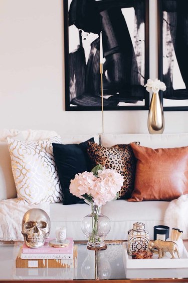 living room with black wall art, gold vase, leopard print pillow
