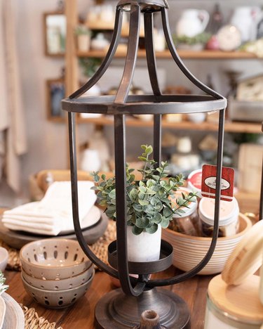 table with plant inside iron lantern