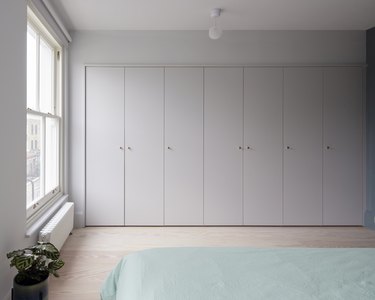 A wall of storage in the bedroom.