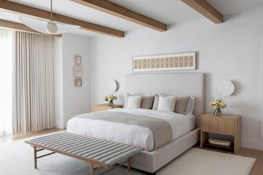 neutral bedroom with pillows, white sheets and sophisticated bed styling