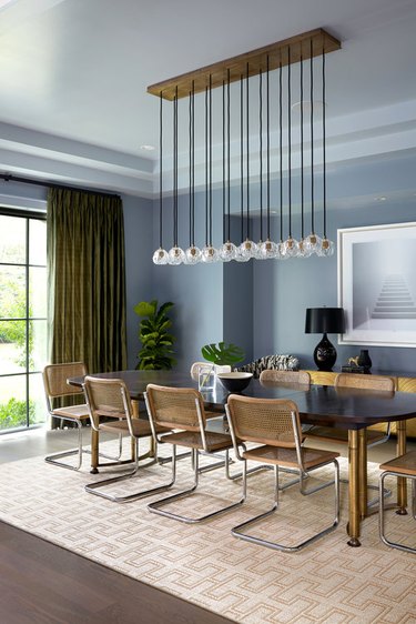 Modern contemporary dining room with bubble chandelier, blue gray walls and olive green curtains