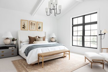 neutral bedoom with white bedding and gray throw and brown pillows