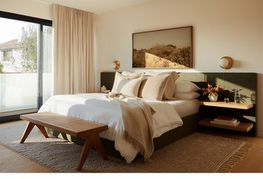 bedroom with upholstered green headboard and lots of pillows
