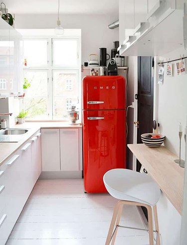 kitchen with white cabinets and red fridge