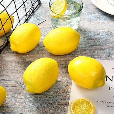 Image of faux lemons on a grey wooden table