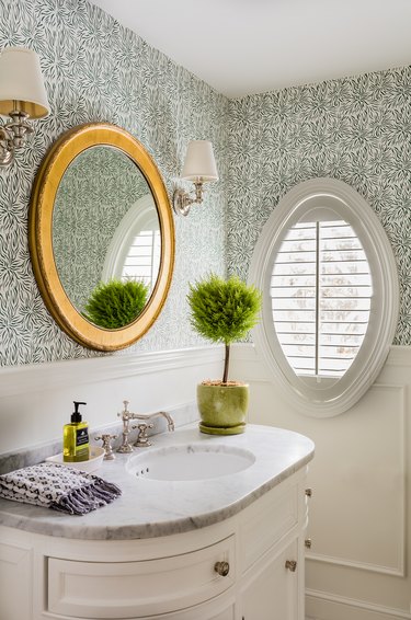 Coastal wallpapered bathroom with minimal light fixtures by KT2 Design Group