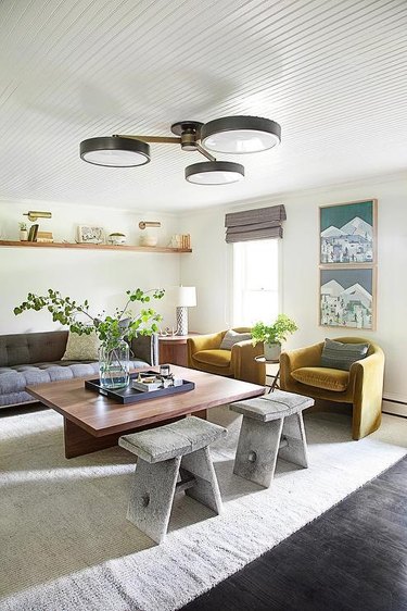 room with gray couch and mustard yellow chairs