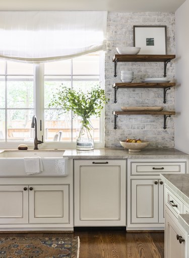 Farmhouse kitchen with brick walls by Marie Flanigan Interiors