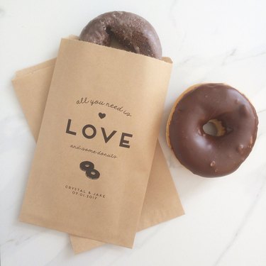 Two brown doughnut bags with the text: all you need is love and some doughnuts