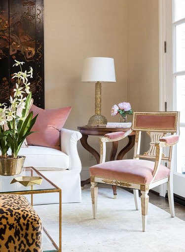 living room with champagne walls and pink velvet chair and pillow