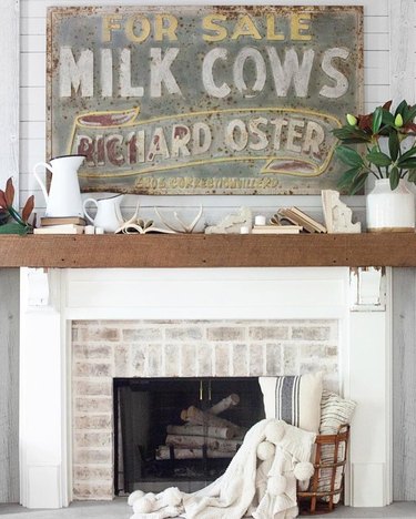 Farmhouse style fireplace with vintage sign.