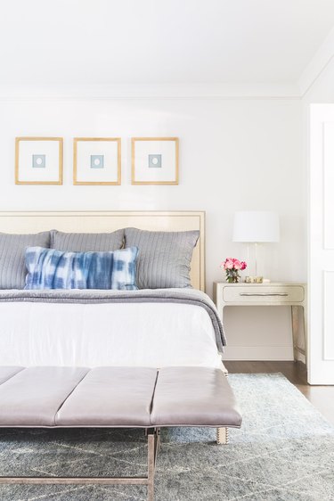 bedroom with champagne headboard and gray pillows