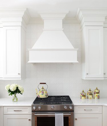 white kitchen with yellow patterned ginger jars and tea kettle