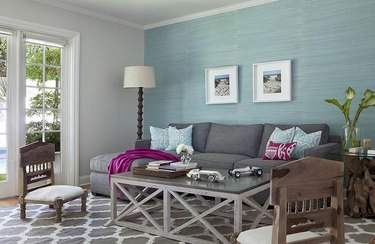 room with gray couch and aqua wall