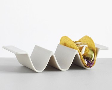 white taco holder with taco on table