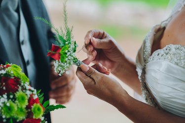 bride putting on boutonnière