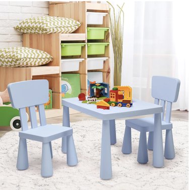 kids' playroom with storage in green bins along the wall and a light blue table and chair set