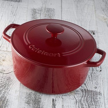 Cuisinart red dutch oven on a gray-washed wooden surface
