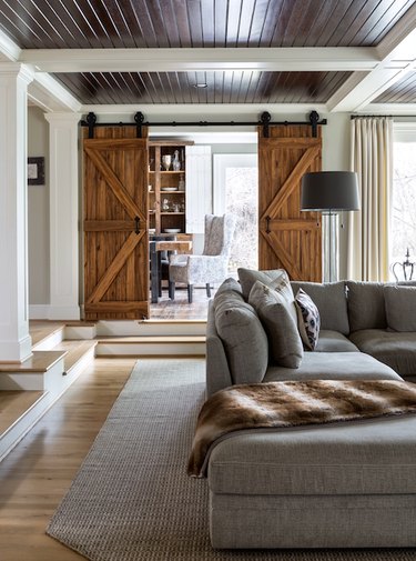 farmhouse interior with neutral furnishings, barn door and sunken floor