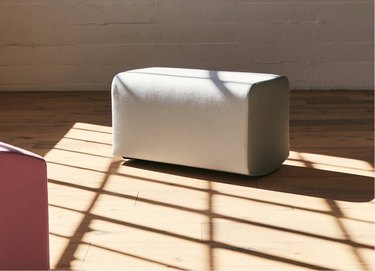 A curved white ottoman.