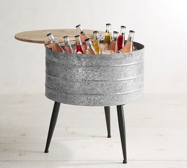 Round metal stand-up cooler with long black legs and wood top