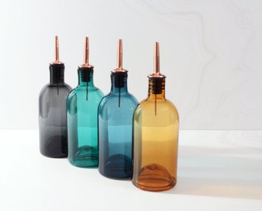four oil/vinegar bottles in various colors