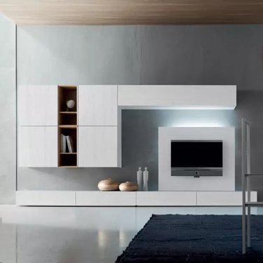A white livingroom tv stand and cabinets with biased lighting