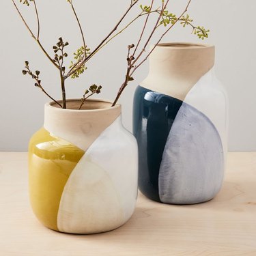 Pair of ceramic vases with abstract design; one is navy blue and the other is marigold