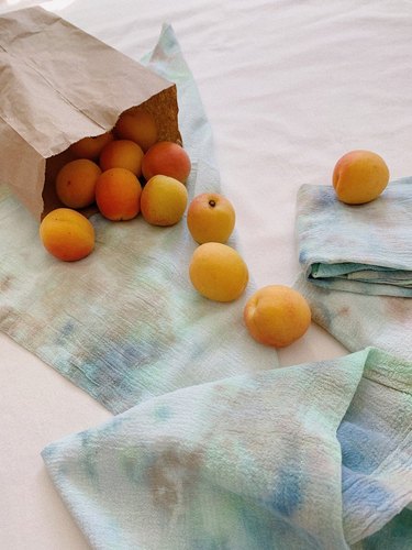bag of tangerines spilling onto colorful cloth napkins