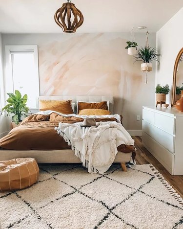 A boho style bedroom with muted colors and layered textures