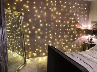 fairy lights running down a full bedroom wall