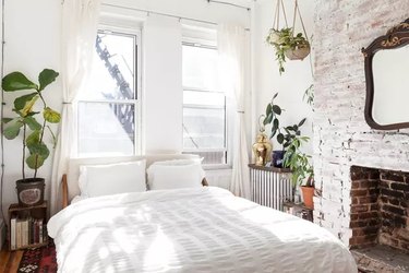 White, bright bedroom with a brick wall fireplace