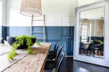 Dining room with wall that is cream on top and navy at the bottom.