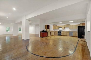 A kitchen with a basketball free-throw line marked on the wood floor