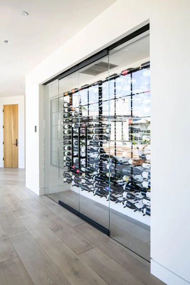 Wine collection behind glass wall in home