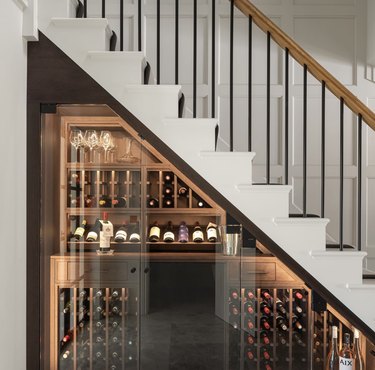 Wine collection stored under stairs