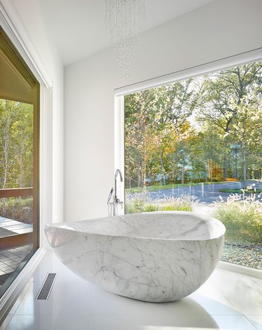 Marble tub in the corner of a bathroom.