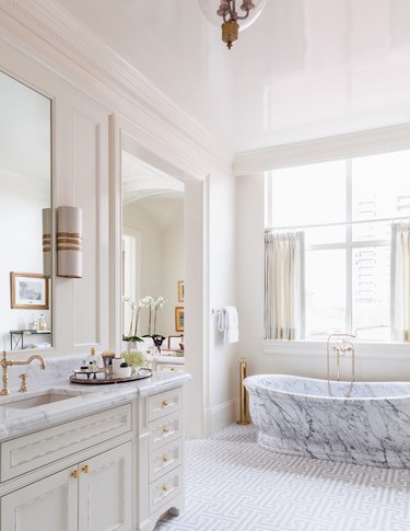 Black marble tub in a white bathroom.